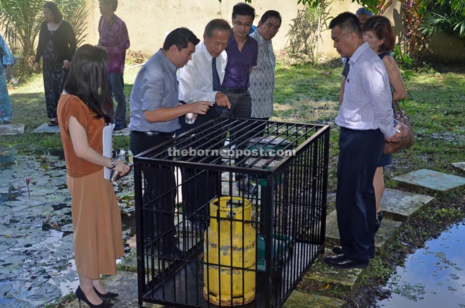 Tiong (third left) being briefed on how the device works by Loh (second left) while Wong (fourth left), Morshidi (right) and others look on.