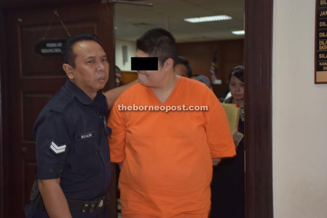 Syukri being escorted out of the court room.