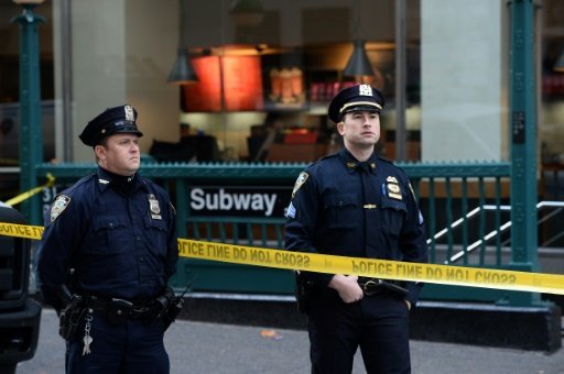 © AFP | New York Police Department (NYPD) officers secure an entrance of a subway station following a shooting incident in New York on November 9, 2015 