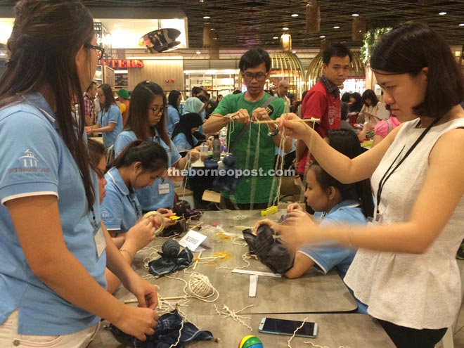 A puppeteer demonstrates making simple marionettes to participants from SEGi College. 