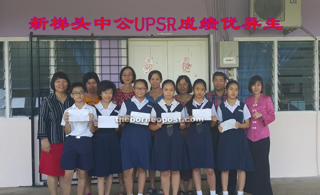 Ling (left) and Liew (second left) with top achievers and their teachers. 