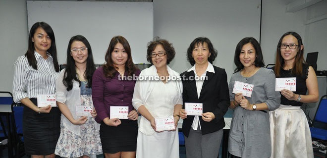 Hiu (third right), SEA Women’s Wing chairman Chua Siew Huay (centre) and other committee members posing with the invitation card to attend the Christmas Appreciation Luncheon.