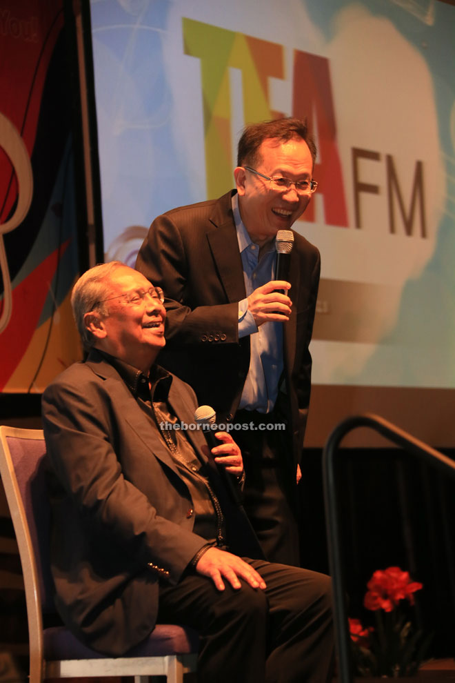 Adenan (seated) shares a light moment with Lau as they attempt to raise funds at the event.