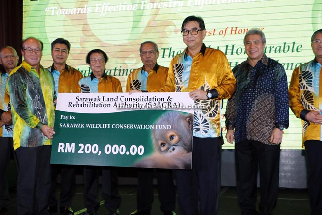 Salcra general manager Datu Vasco Sabat Singkang (second left) presenting the mock cheque to  Sarawak Forestry chief executive officer Wong Ting Chung.