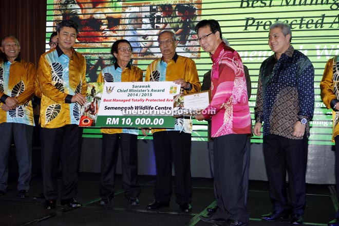 Ministry of Planning and Resource Management’s Permanent Secretary Datu Sudarsono Osman (second left) presenting the mock cheque to Semenggoh Wildlife Centre park manager Chong Jiew Han. Adenan is at fifth left.