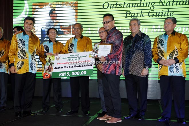 Sudarsono (left) presenting the mock cheque to winner of the ‘Outstanding National Park Guide’ award Azhar Nor Mostapha Nor (third right). Yusoff is on Adenan’s right.