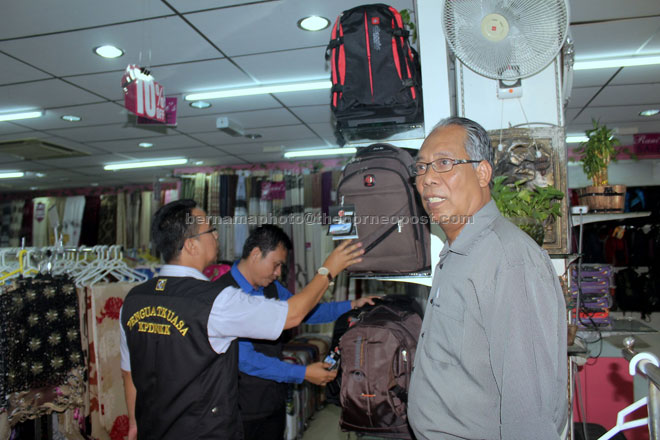 Ariffin (right) with his personnel inspect one of the premises. — Bernama photo