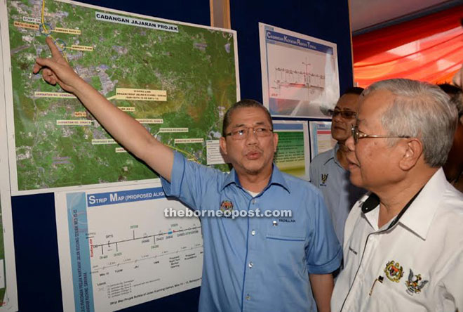 Fadillah (left) showing Manyin the location of the the dual carriageway project from Mile 10th to 15th Kuching/Serian Road.