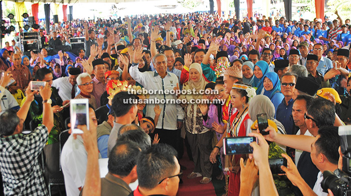 BERSAMA RAKYAT: Adenan (tengah) dan Jamilah disambut meriah sejurus tiba pada majlis itu.