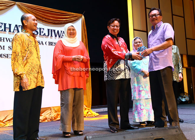 Abang Johari (second right) presents Ariffin with a farewell gift to mark his retirement from RTM. — Photo by Mohd Rais Sanusi