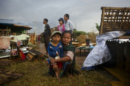 AFP | Residents look on as authorities demolish a slum area on the outskirts of Yangon on January 26, 2016 