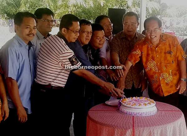 Radin (second right) and the guests cutting the Christmas cake together at the Christmas Open House and New Year celebration held at the Taman Mantailang Neighbourhood Watch Area on Friday.   