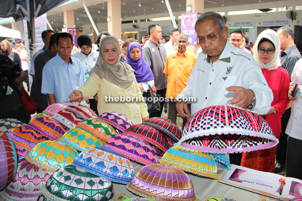 Adenan takes a closer look at a local handicraft item. Also seen are Jamilah (second left) and Fatimah (behind Adenan).