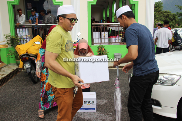 Volunteers help some of the recipients carry their items.