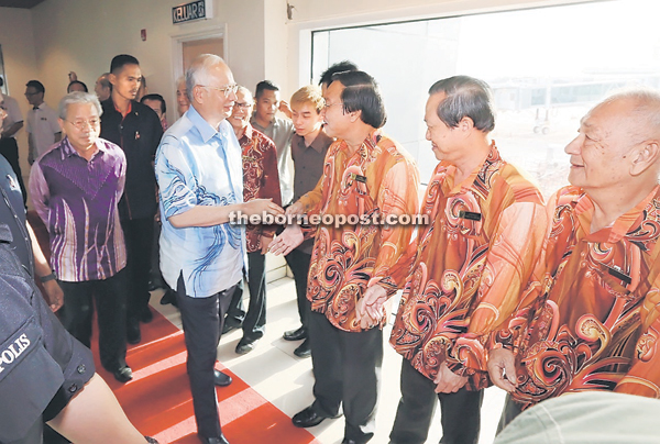 Najib shakes hands with Chinese community leaders who come to welcome him at the aerobridge of the airport. — Photo by Kong Jun Liong