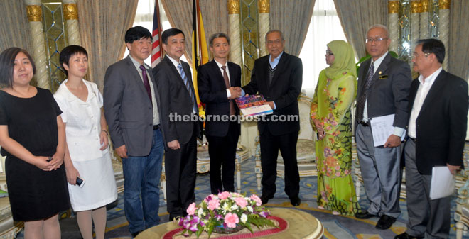 Wu (fifth from left) presents a memento to Adenan during the courtesy call. 