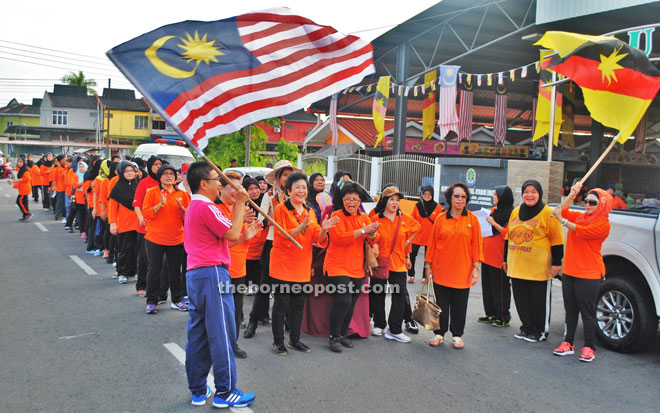 Dr Annuar flags off the participants of ‘Women Walk the World’ walkathon at Kampung Nyabor Malay MUC hall.   