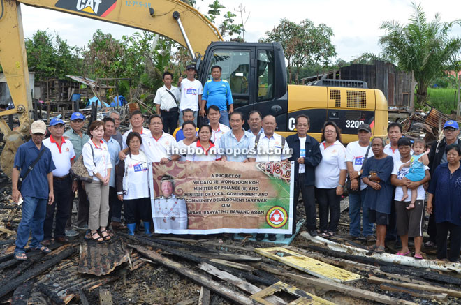 Members of UPP Bawang Assan Bumiputera Unit with the villagers at the site of the burnt longhouse. 