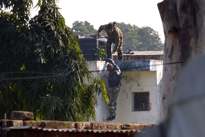 Indian security personnel position themselves on a rooftop at the airforce base in Pathankot. — AFP photo