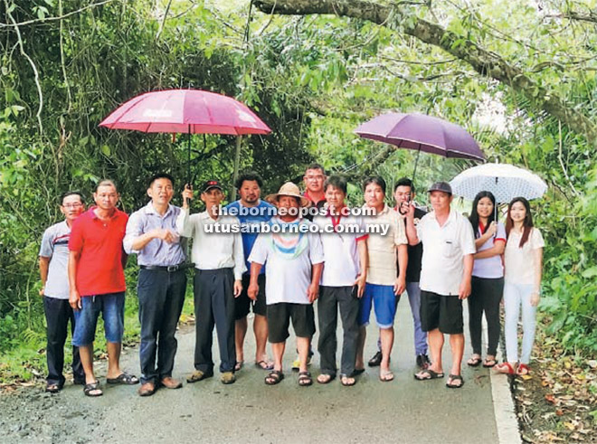 SIAP: Liu (tiga kiri) bersama ahli UPP Batu Kawa dan penduduk bergambar bersama-sama sebelum bersama-sama membersihkan pokok yang tumbang di atas jalan raya. 