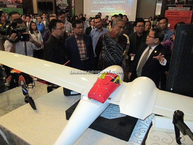 Sains chief executive officer Dato Teo Tien Hiong (right) explains to Adenan how the drone technology works. Standing right next to Adenan is Sains chairman Datuk Patinggi Tan Sri Dr George Chan. — Photos by Jeffery Mostapa