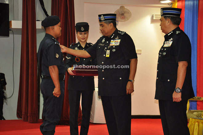 Khalid (second right) affixes Pingat Kedaulatan Negara on a police personnel who served during ‘Ops Daulat’ in Sabah in 2013 while Muhammad Fuad (right) looks on. 
