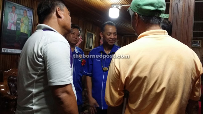 Penguang (second right) having a light moment with his supporters during the meet-the-people session in his longhouse recently.