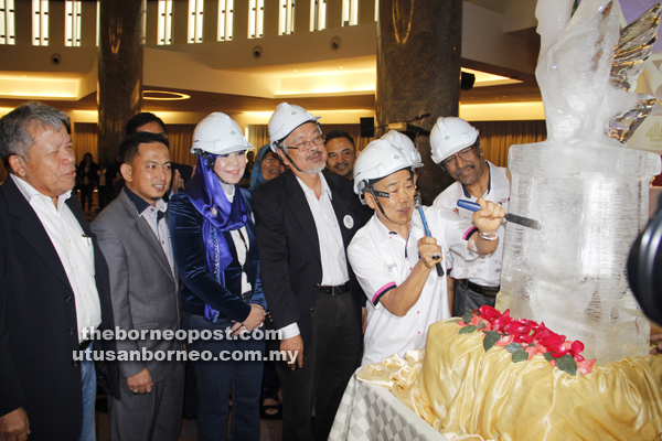 SIMBOLIK: Naroden menukul batu ais sebagai simbolik perasmian seminar sambil disaksikan Abang Helmi (empat kiri) serta Pengerusi Dewanita Sarawak Juita Drap (tiga kiri) dan yang lain.