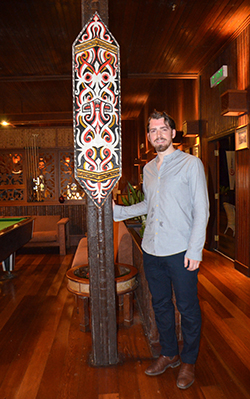 Brooke standing beside an Iban shield at the Resort.