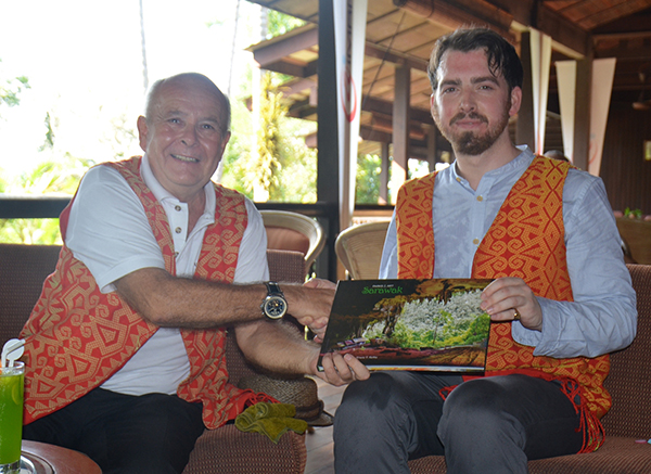 Aiman Batang Ai Resort and Retreat general manager Keith Pointer hands over a book  on parks and arts in Sarawak to Brooke after the signing ceremony.