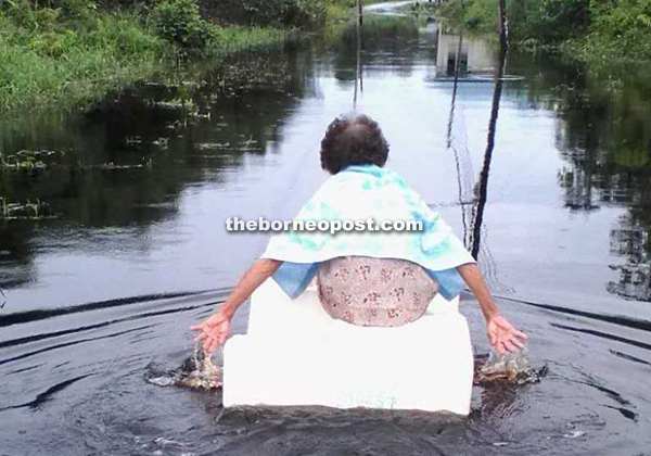 A resident using an improvised boat to paddle home.