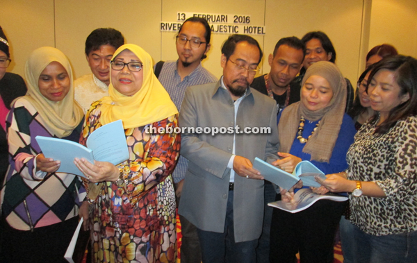 Rohani (second left) looking at a copy of the Children’s Act (Amendment) 2015 with members of the media yesterday.