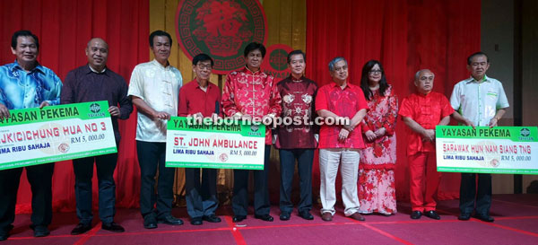 Abang Khalid (sixth right) with Abang Ismail (fourth right) and other guests pose for a photo with donation recipients at the event. 