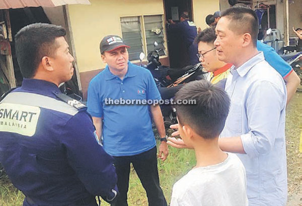 See (right) in a discussion with an officer from the Special Malaysia Disaster Assistance and Rescue Team (SMART) from Putrajaya, who was at Kampung Tabuan Dayak yesterday to inspect the damage caused by the flash flood. 