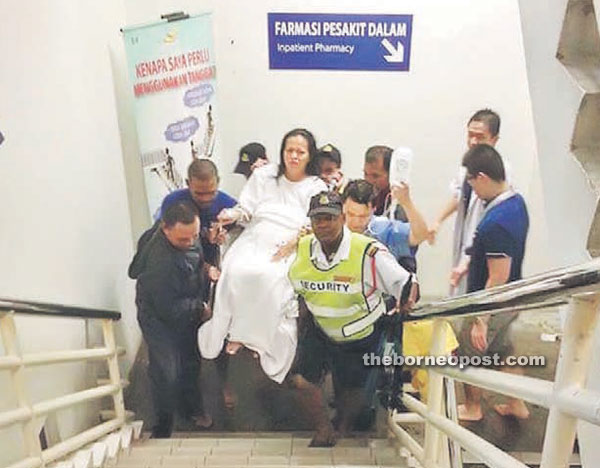 SGH personnel carry a patient to a higher floor. 