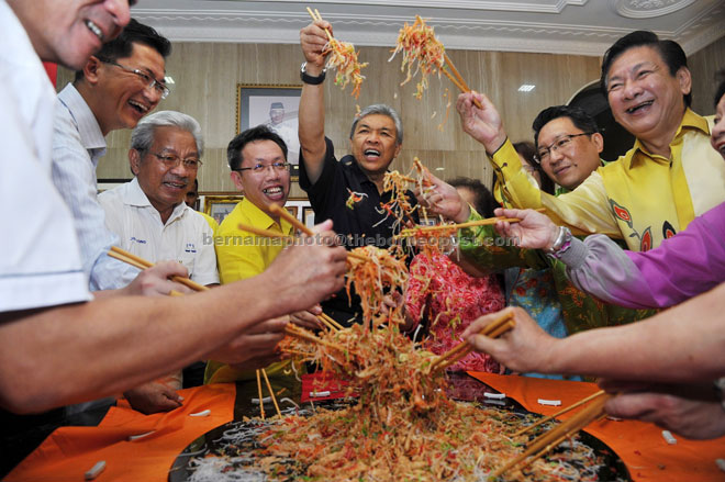 Ahmad Zahid leads the tossing of the ‘Yee Sang’ during the visit to SUPP president Prof Datuk Dr Sim Kui Hian (on Zahid’s right), who held a Chinese New Year open house yesterday. — Bernama photo