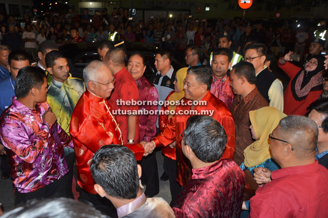 SEMARAK KEMERIAHAN: Najib (kiri) disambut mesra oleh Setiausaha Negeri Sarawak Tan Sri Datuk Amar Mohd Morshidi Abdul Ghani pada Majlis Rumah Terbuka Malaysia Tahun Baharu Cina 2016 di Dataran Bandar Sibu, malam tadi.