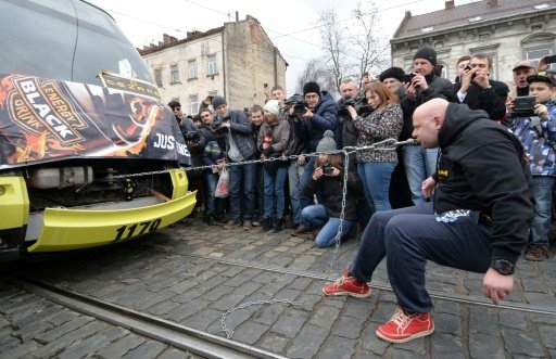 AFP | Ukrainian children's doctor Oleg Skavysh pulls five tramcars over a stretch of 14 meters (46 feet) in Lviv on February 26, 2016 