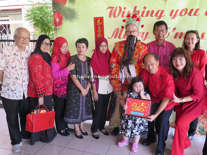 Yong (squatting) and his wife, Datin Mary Yong celebrating Chinese New Year with the disabled children at Taman Jaya Likas yesterday.