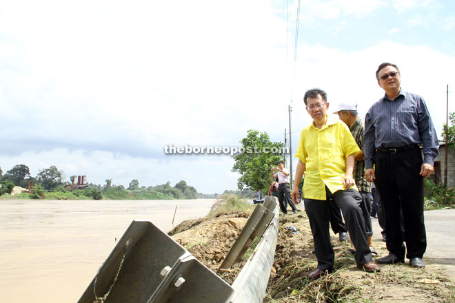 Dr Sim (left) and Lo look at the condition of the riverbank erosion at Rantau Panjang — Photo by Chimon Upon