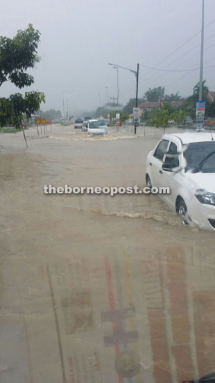 Motorists brave the flood waters at Taman Malihah.