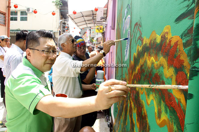 (From left) Wee, Abdul Wahap and Pearmain putting their personal touch on a wall of Kai Joo Lane. —  Photos by Chimon Upon.  