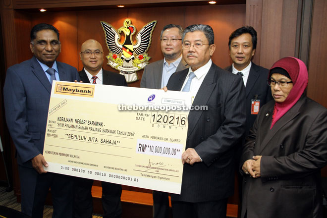 Irwan (left) hands over the mock cheque to Morshidi, witnessed by others. — Photo by Chimon Upon