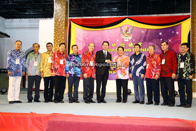 Wong (fifth right) presenting a gift to Zhu as Fu (fourth right), Lu (sixth left) and others look on. — Photo by Muhammad Rais Sanusi