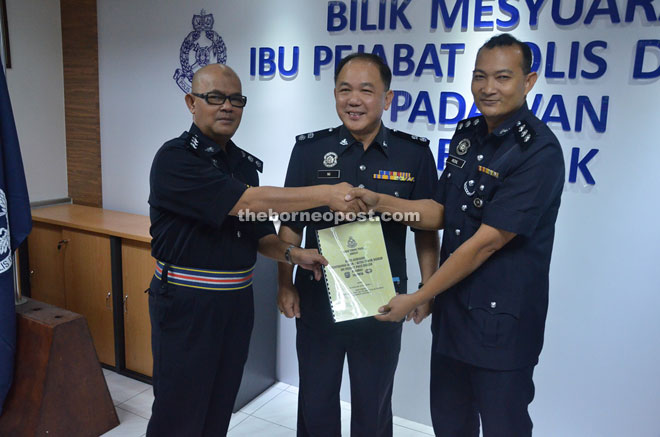 Ng witnesses the handover of duty between Othman (left) and Muhamad Rizal.