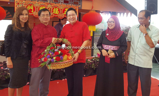 Wee (centre) receives a memento from Ng. Kartina is at second right.