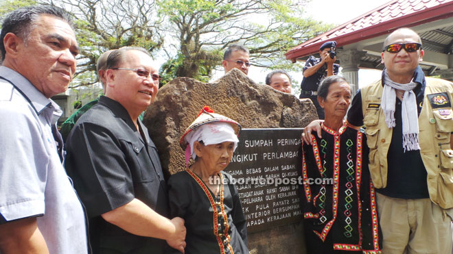 Nazri (right) with Pairin (second left) and Yusop (left) taking photograph with two Bobolians in front of the Oath Stone.  