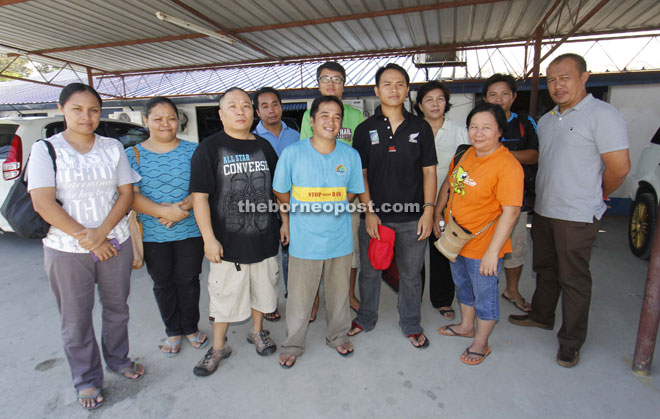 Nousi (centre), and fellow activists  at the Penampang police station yesterday. 