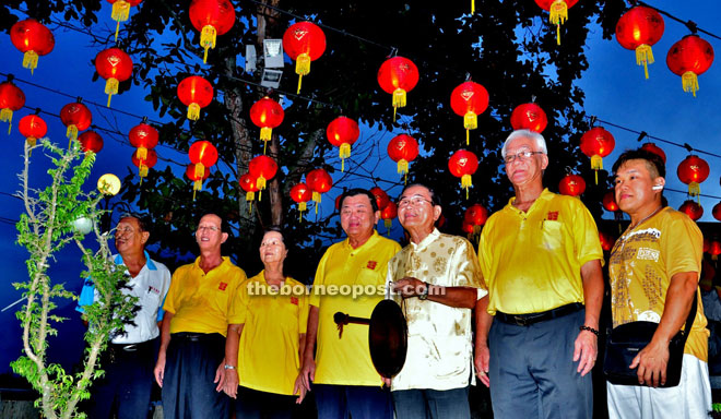 Soon (third right) beats the gong to symbolically switch on the red lanterns at Tua Pek Kong Temple.