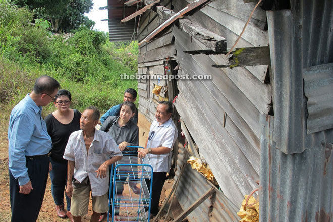 SJA committee members led by Francis Fahir (right) and Kassim Sangi (left) visited Liew's rotten wooden and zinc house at Kampung Gudon yesterday. 